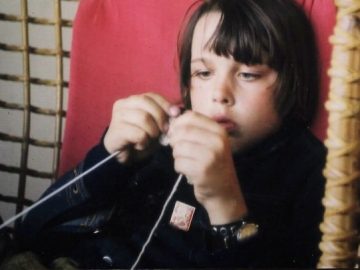 Young Mikko sitting and knitting